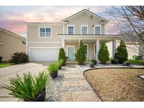 Charming two-story home features a well-manicured front yard, inviting entryway, and attached garage at 166 Pavilion St, Summerville, SC 29483