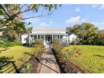Charming home featuring a metal roof, blue shutters, inviting front porch, and a picturesque garden walkway at 1808 Ion Ave, Sullivans Island, SC 29482