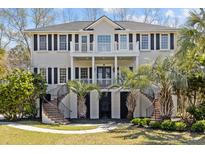 Stunning home with dual staircases, second story balcony, lush landscaping, and mature palm trees at 2041 Ashburton Way, Mount Pleasant, SC 29466