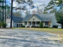 Charming home with a cozy front porch, well-manicured lawn, and ample parking space at 2164 Highway 78, Dorchester, SC 29437