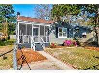 Charming home featuring a screened-in porch and beautifully landscaped front yard with colorful flowers at 2314 Kent Ave, North Charleston, SC 29405