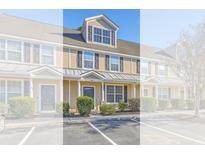 Inviting townhouse with tan siding, black shutters, well-kept landscaping, and convenient parking at 309 Hemingway Cir, Summerville, SC 29483
