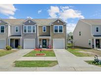Charming townhome with neat lawn, tidy landscaping, garage, and appealing architectural details at 124 Gaura Ln, Summerville, SC 29483