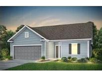 Charming single-story home with light blue siding and a two-car garage in a well manicured lawn at 133 Royal Cainhoy Way, Huger, SC 29450