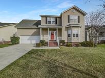 Charming two-story home with a red door, landscaped yard, attached garage, and well-maintained lawn at 159 Antebellum Way, Summerville, SC 29483