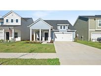 Charming single-Gathering home featuring a covered porch and a two-car garage on a well-manicured lawn at 173 Paddle Boat Way, Summerville, SC 29485