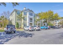 Exterior view of a light green and white multi-story condo building with ample parking at 1822 Chatelain Way, Mount Pleasant, SC 29464