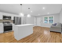 Bright, open kitchen features stainless steel appliances, white cabinets, and a large island with pendant lighting at 1873 Hazelwood Dr, Charleston, SC 29407