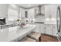 Bright kitchen features white cabinets, stainless steel appliances, quartz countertops, and a stylish kitchen island with seating at 2800 Lacy St, North Charleston, SC 29406