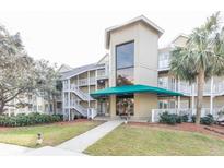 Inviting condo building with lush landscaping and a covered entrance perfect for coastal living at 302 Palmetto Dr # A-302, Isle of Palms, SC 29451