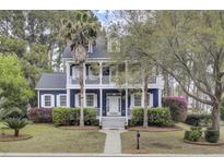 Charming two-story home with a double porch, lush landscaping, and a well-manicured lawn at 3409 Southern Cottage Way, Mount Pleasant, SC 29466