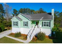Charming elevated home with lush landscaping, stairs to entry, and a welcoming porch at 4281 Jacobs Point Ct, Ravenel, SC 29470