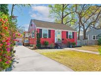 Charming red cottage-style home with a yellow door, neat landscaping, and inviting curb appeal at 4816 Parkside Dr, North Charleston, SC 29405