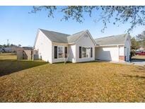 Well-maintained single-story home with white siding and a manicured front lawn on a sunny day at 5020 Holdsworth Dr, Summerville, SC 29485