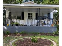 Charming front porch with black iron railing, plants, and seating area with cute cats enjoying the outdoor space at 5834 Beverly Dr, Hanahan, SC 29410