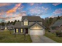 Inviting two-story home with a two car garage, manicured lawn, and picturesque evening sky at 629 English Oak Cir, Moncks Corner, SC 29461