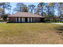 Charming brick ranch-style home featuring a carport and well-maintained lawn at 105 Wade Ct, Summerville, SC 29486