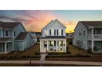 Charming two-story home featuring a welcoming front porch and lovely landscaping, perfect for relaxing evenings at 115 Winding Branch Dr, Summerville, SC 29486