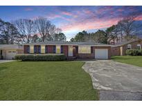 Charming brick ranch with a well-manicured lawn, attached garage, and inviting front entrance at 1264 Fort Dr, Hanahan, SC 29410