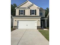 Charming two-story home featuring a two-car garage, stone accents, and a well-manicured lawn at 176 Daniels Creek Cir, Goose Creek, SC 29445