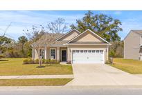 Charming single-story home with a well-manicured lawn and attached two car garage at 2025 Elvington Rd, Johns Island, SC 29455