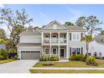 Charming two-story home featuring a double porch, attached garage, and landscaped yard at 2335 Brinkley Rd, Johns Island, SC 29455