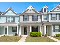 Charming townhome features colorful exteriors, a well-manicured lawn, and a covered front porch at 407 Stoneleigh Ln, Moncks Corner, SC 29461