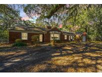 Charming brick home with mature trees, a private driveway and lush greenery all around the property at 562 Fort Johnson Rd, Charleston, SC 29412