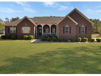 Charming brick home with a well-manicured lawn and inviting front porch at 760 Community Ave, Smoaks, SC 29481