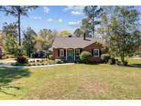 Charming brick home with a well-manicured lawn and classic design with inviting curb appeal and mature trees at 107 Minus St, Saint George, SC 29477