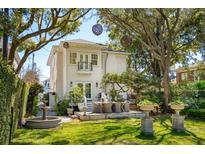 Beautiful backyard featuring a seating area on a stone patio, a fountain and beautiful landscaping at 184 Tradd St, Charleston, SC 29401