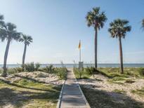 Scenic beach view with palm trees, a wooden boardwalk, and the ocean in the background at 259 Sea Cloud Cir, Edisto Island, SC 29438