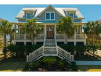 Charming coastal home with a welcoming front porch, beautiful landscaping and palm trees at 2722 Crooked Stick Ln, Mount Pleasant, SC 29466