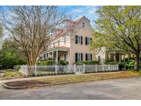 Charming two-story home with a red roof, white picket fence, and beautifully landscaped yard at 42 Sowell St, Mount Pleasant, SC 29464