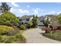 Traditional white home with an attached garage and lush, mature landscaping around the driveway at 649 Pawley Rd, Mount Pleasant, SC 29464