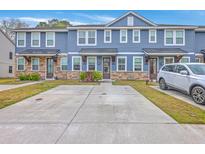 Charming townhomes featuring stone accents, blue siding, and a convenient two-car driveway at 7803 Park Gate Dr, Charleston, SC 29418