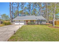 Charming single-story home featuring a well-manicured lawn, mature trees, and a two-car garage at 891 Wynford Ct, Mount Pleasant, SC 29464