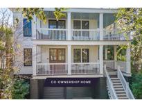 Charming two-story home featuring double balconies, white railings, and a welcoming entrance with a beautiful outdoor setting at 108 Carolina Blvd, Isle of Palms, SC 29451