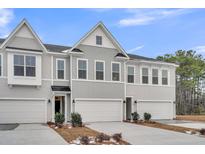 Beautiful townhome exterior with attached garages and manicured landscaping under a blue sky at 110 Brown Swiss Cir, Summerville, SC 29483