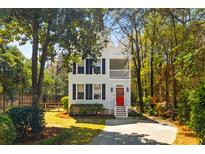 Charming two-story home features a red front door, white trim, and lush landscaping at 1100 Sea Island Crossing Ln, Mount Pleasant, SC 29464