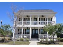 Charming two-story home with a double porch, white columns, black shutters, and a well-manicured lawn at 112 Carpenter St, Summerville, SC 29486