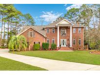 Stately brick home boasts manicured lawn, columned entrance, and professionally landscaped front yard at 1164 Out Of Bounds Dr, Summerville, SC 29485