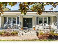 Charming brick home featuring a welcoming front porch with seating and a meticulously landscaped entrance at 1200 Island View Dr, Mount Pleasant, SC 29464
