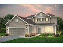 Charming two-story home with a manicured lawn and a two-car garage, offering classic curb appeal at 125 Royal Cainhoy Way, Huger, SC 29450