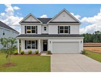 Charming two-story home with landscaped front yard and attached two-car garage at 134 Palfrey Dr, Ridgeville, SC 29472