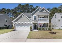 Charming two-story home with a double porch, a manicured lawn, and an attached two-car garage at 165 Vango Dr, Goose Creek, SC 29445