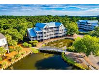Exterior view of the condo building with water, trees and a bridge at 2472 Racquet Club Dr, Seabrook Island, SC 29455