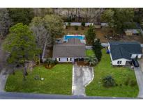 Inviting single-story home with a backyard pool, lush lawn, and a long private driveway at 3308 Island Estates Dr, Johns Island, SC 29455