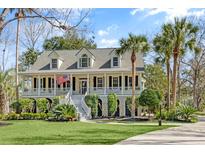 Charming two-story home with a welcoming front porch, manicured lawn and American flag at 5010 Timber Race Crse, Hollywood, SC 29449