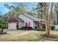 Charming single-story home featuring a well-manicured lawn, complemented by vibrant red shutters and a brick-accented garage at 8095 Old London Rd, North Charleston, SC 29406